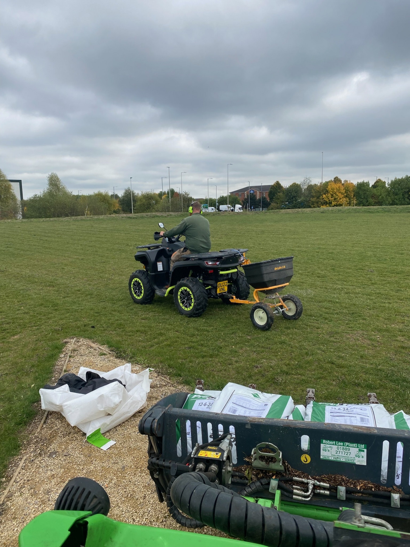 Landywood operator towing a spreader across a large sports field